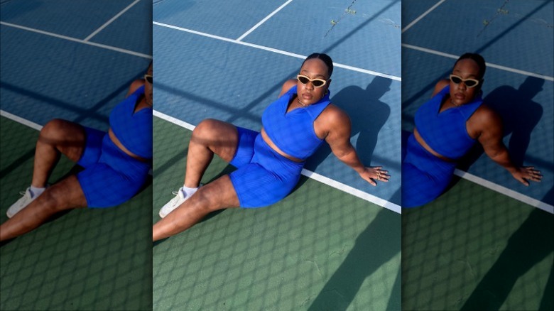 woman laying on tennis court