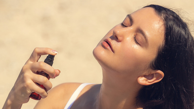 Close up of woman spraying on skincare