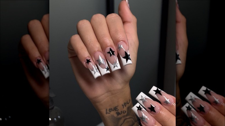 woman with black and chrome star nails