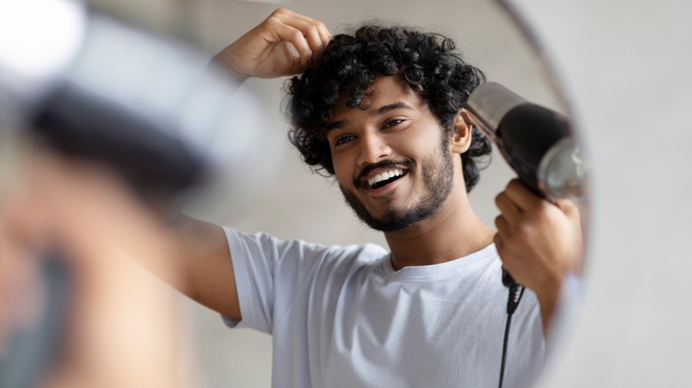 Man drying his curly hair