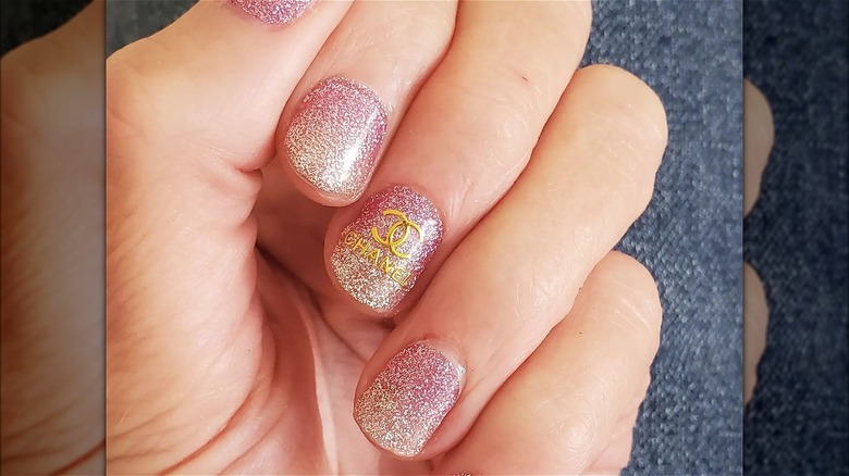 hand with pink gold chanel nails