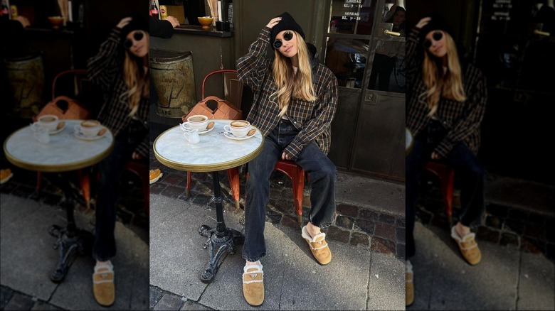 A woman wearing shearling slippers outdoors