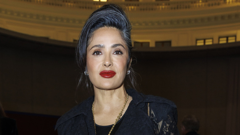 Salma Hayek in a black dress and an elegant updo with her grays showing