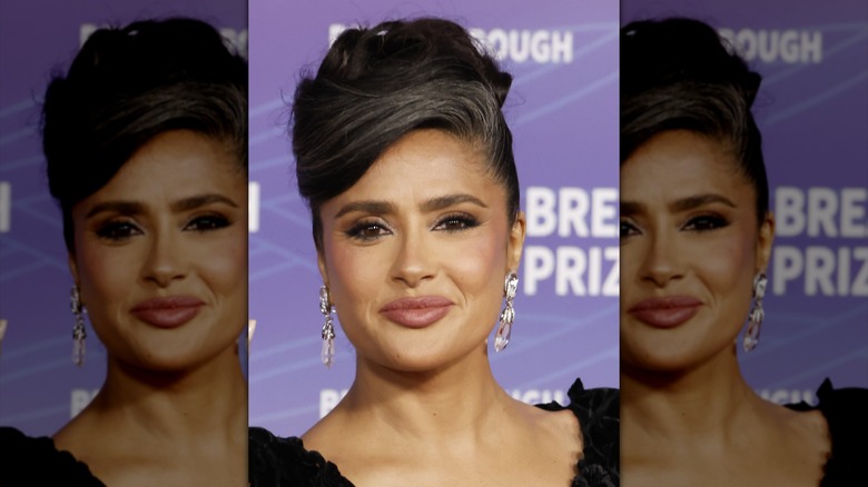 Salma Hayek in a black dress and an elegant updo with her grays showing