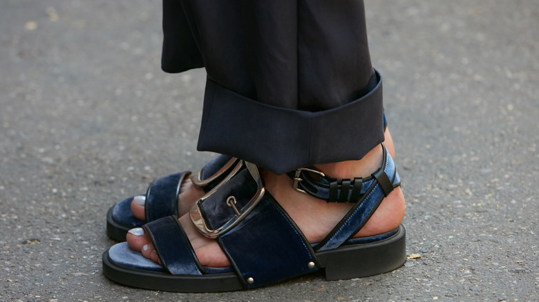 A person wearing a pair of gladiator-style sandals