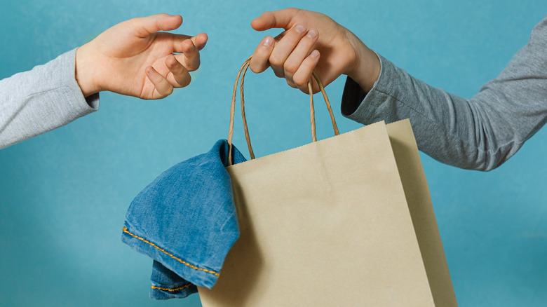 Person passing bag of clothes