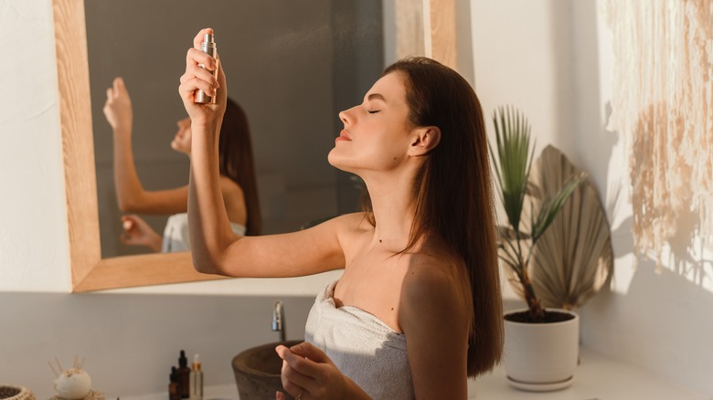 girl using setting spray on face