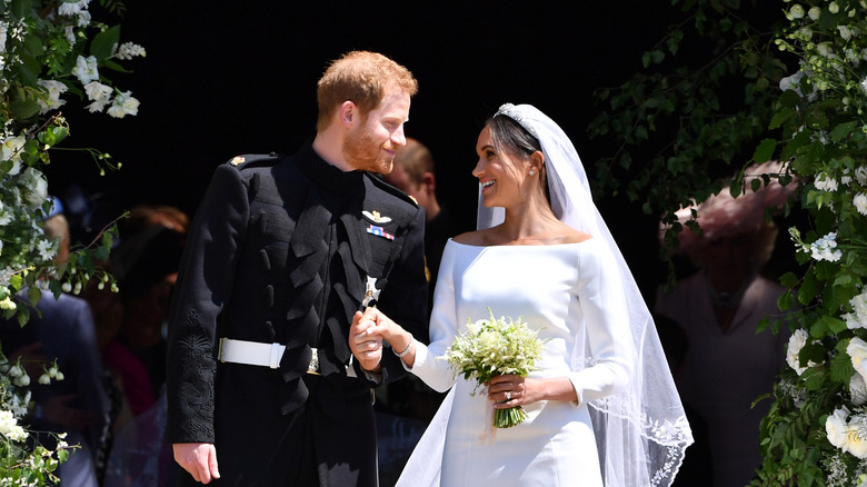 Prince Harry and Meghan Markle pictured on their wedding day smiling at each other.