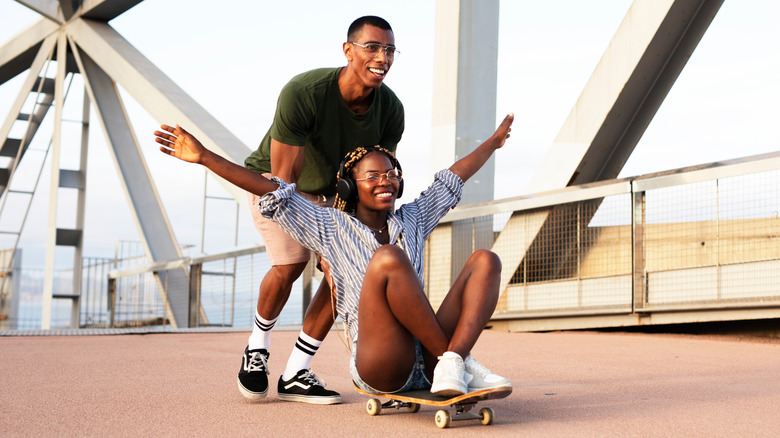 Young couple playing on skateboard