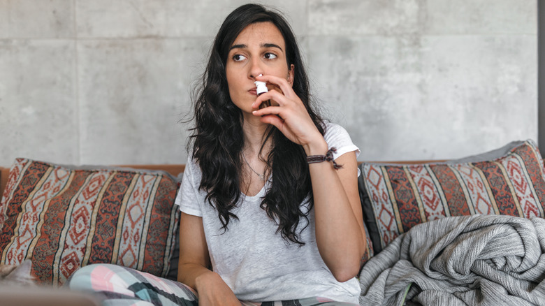 Woman snorts nasal spray