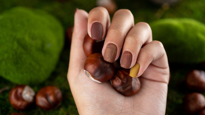 Nails painted brown and yellow 