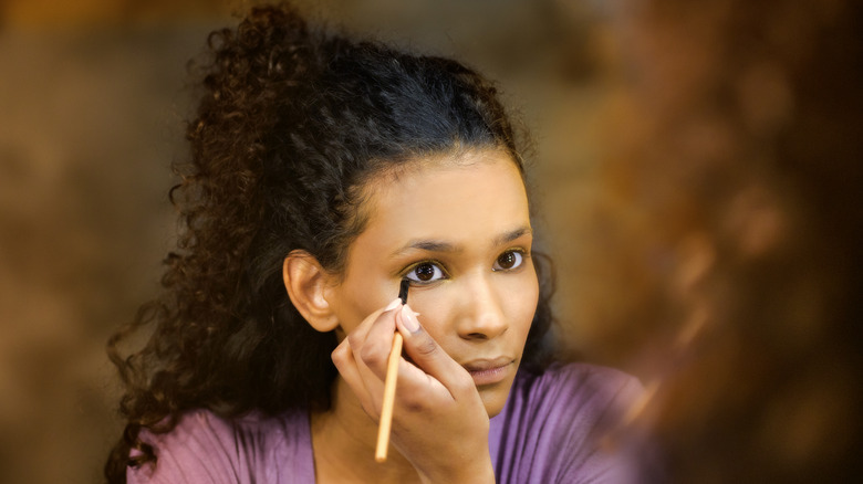 woman applying eyeliner