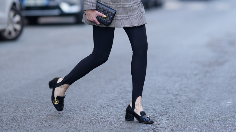 Woman wearing black stirrup leggings with loafers