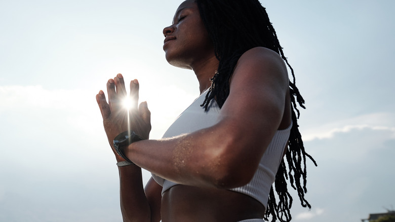young black woman meditating on the beach