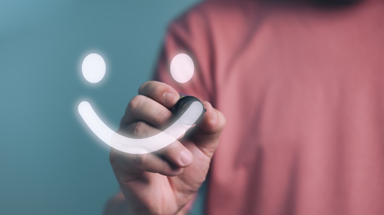 Person drawing happy face