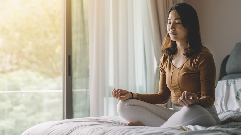 Woman meditating on bed