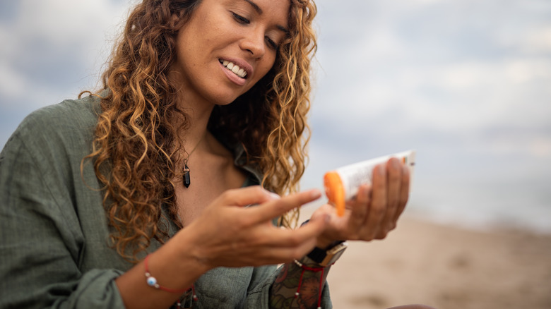 Woman applying sunscreen on beach