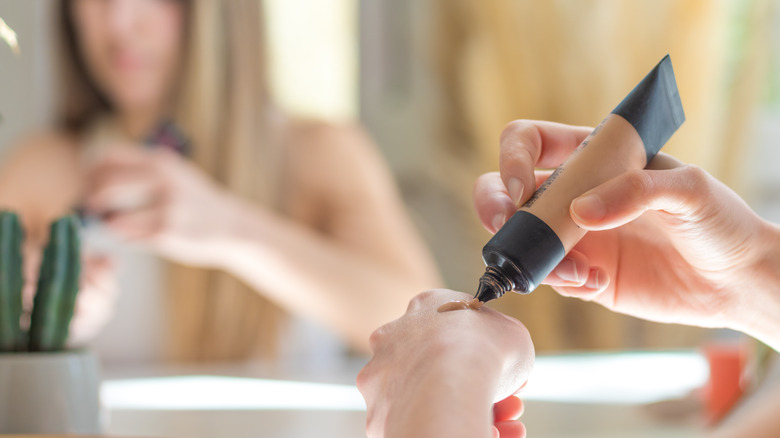 woman applying skin tint to hand