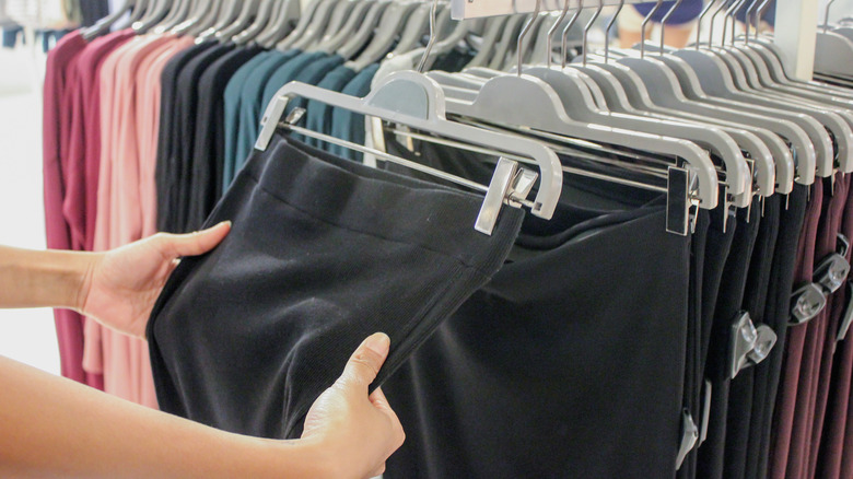 hands touching leggings in store