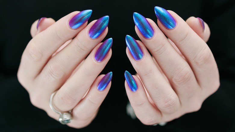 A woman's hands with blue chrome nails.