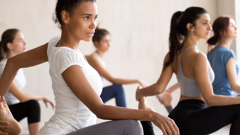 a group of female workout  lifting knees