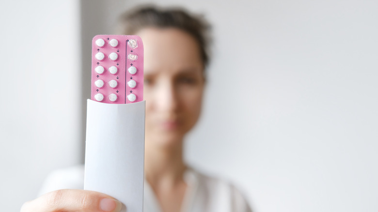 woman holding birth control pills