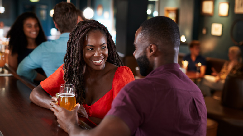Man and woman talk at a bar