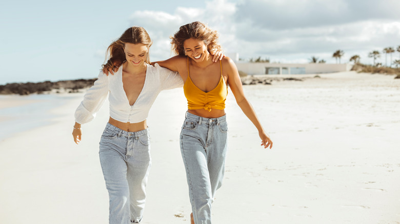 Two friends walking on beach 