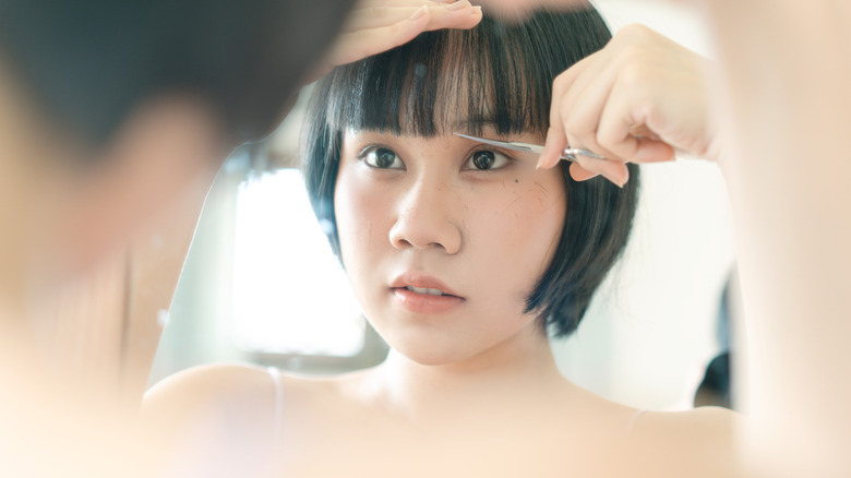 Woman cutting her own bangs
