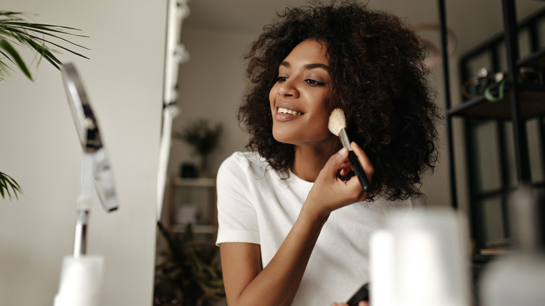 woman putting on makeup