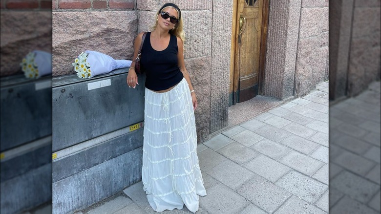 woman wearing black top and long white tiered skirt