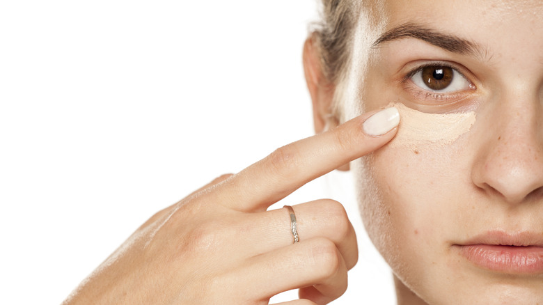 Woman applying concealer 