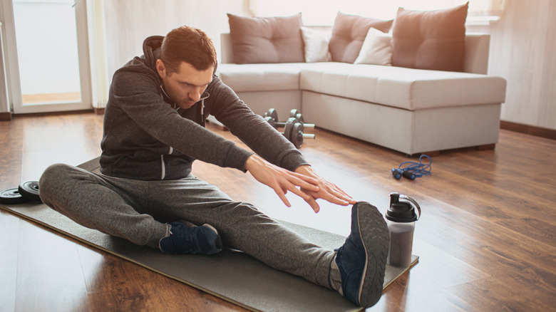 man stretching in living room