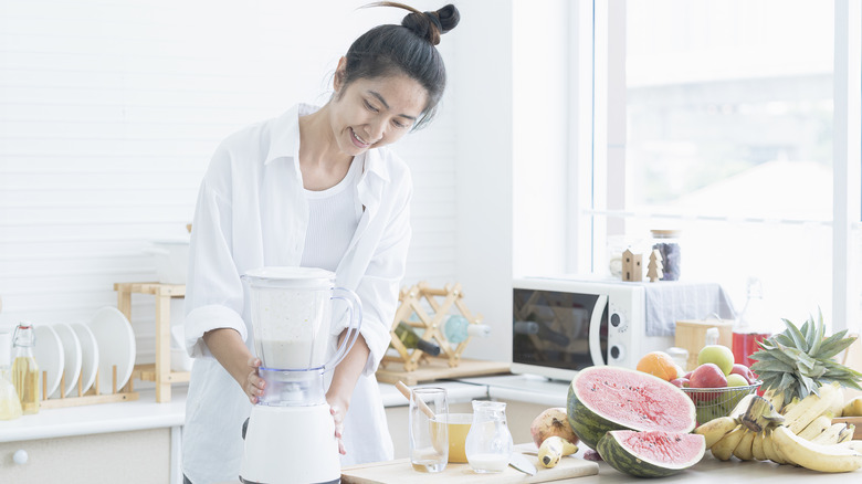 Woman operates blender 