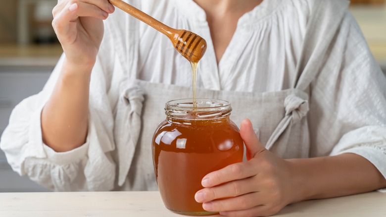 Woman pouring honey