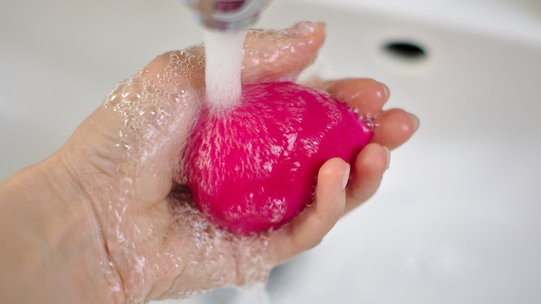 Beautyblender being rinsed.