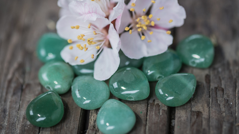 aventurine and pink flowers on wood background