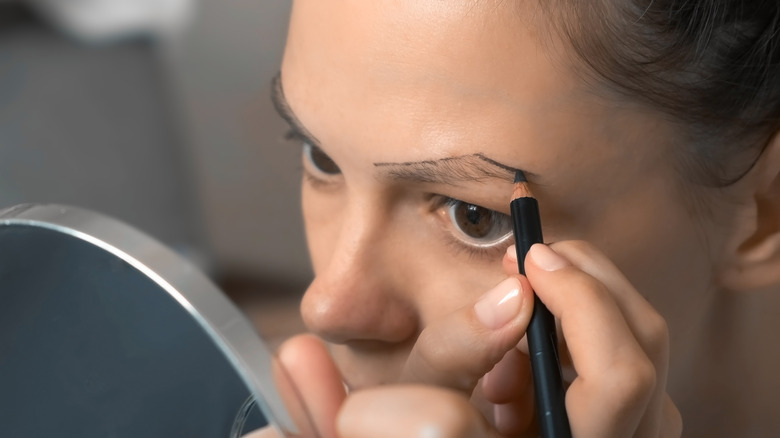 Woman using brow pencil