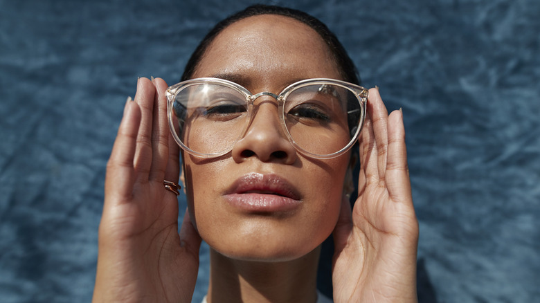 A person wearing clear oversized glasses