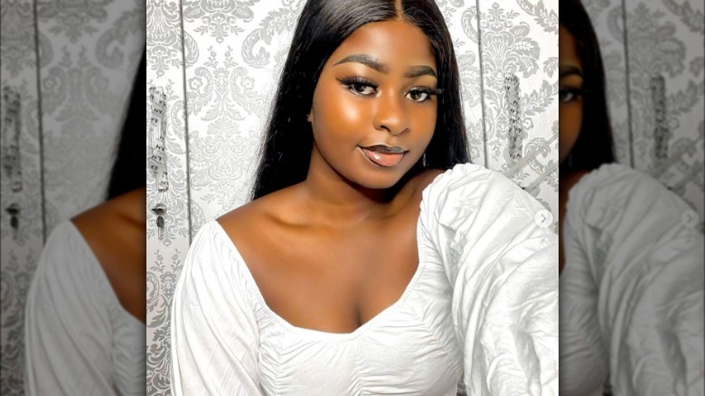 Woman in white dress and black smokey eye