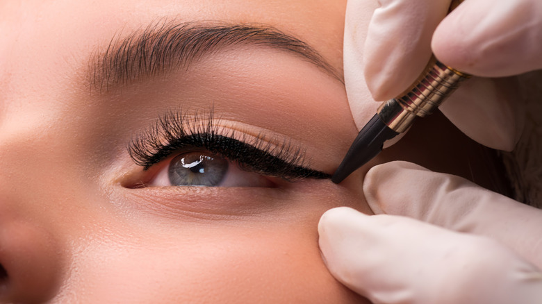 Professional applies eyeliner