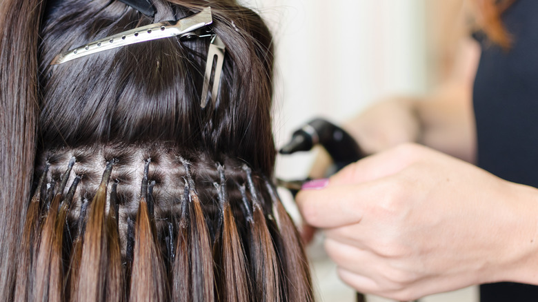 Woman getting hair extensions