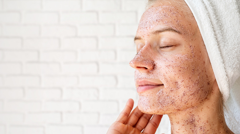 Woman applying a scrub to her face