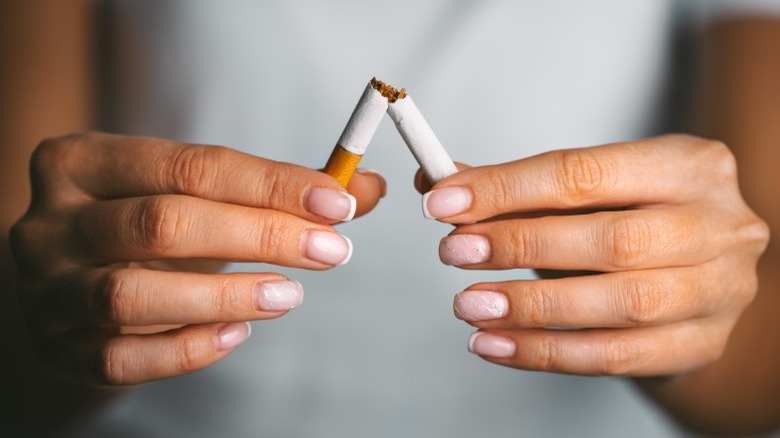 Woman breaking cigarette in half