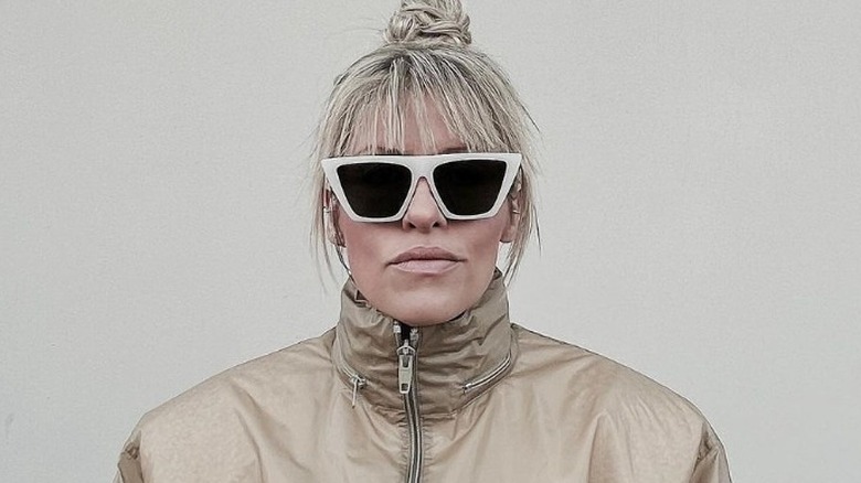 Woman poses in blocky cat-eye sunglasses