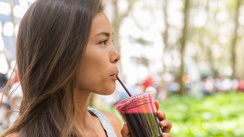 woman drinking smoothie through straw
