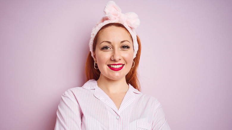 A woman with red hair wearing a pink headband