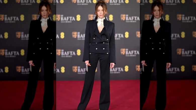 Milly Alcock stands on the BAFTAs red carpet
