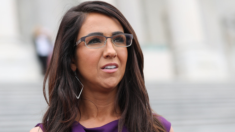 Lauren Boebert wears glasses and a purple dress while standing outside in Washington DC