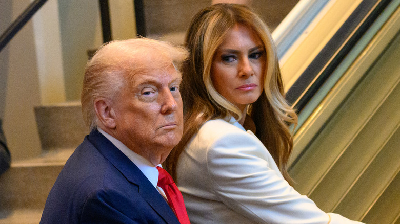 Melania Trump looking back at Donald Trump who is looking away